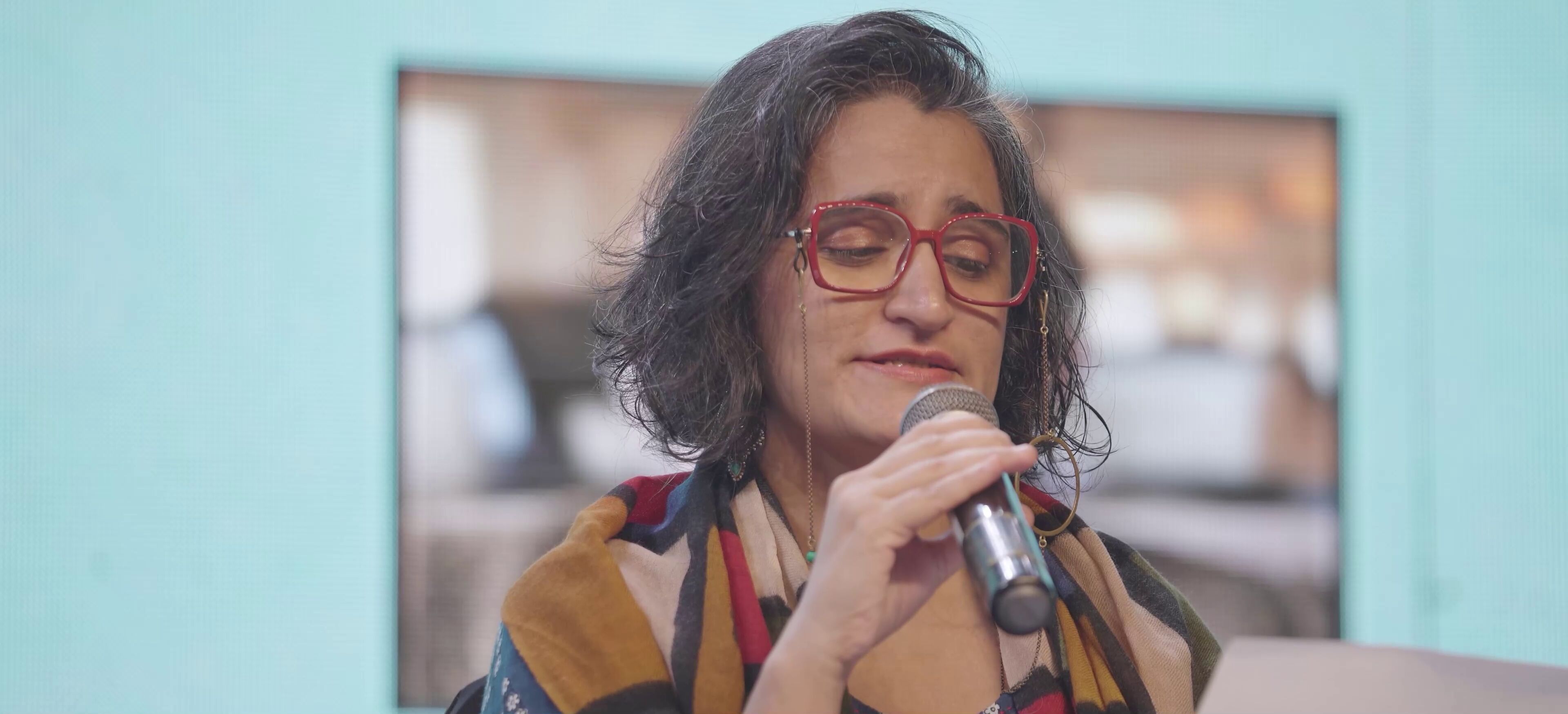 A poet holding flowers while reciting verses during an intimate session